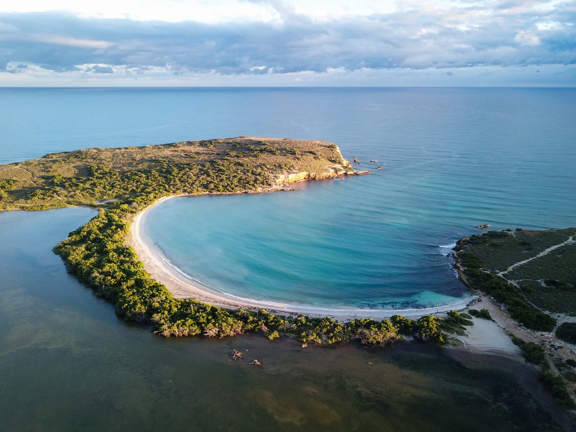 A calm turquoise Puerto Rico bay curving around a green peninsula.