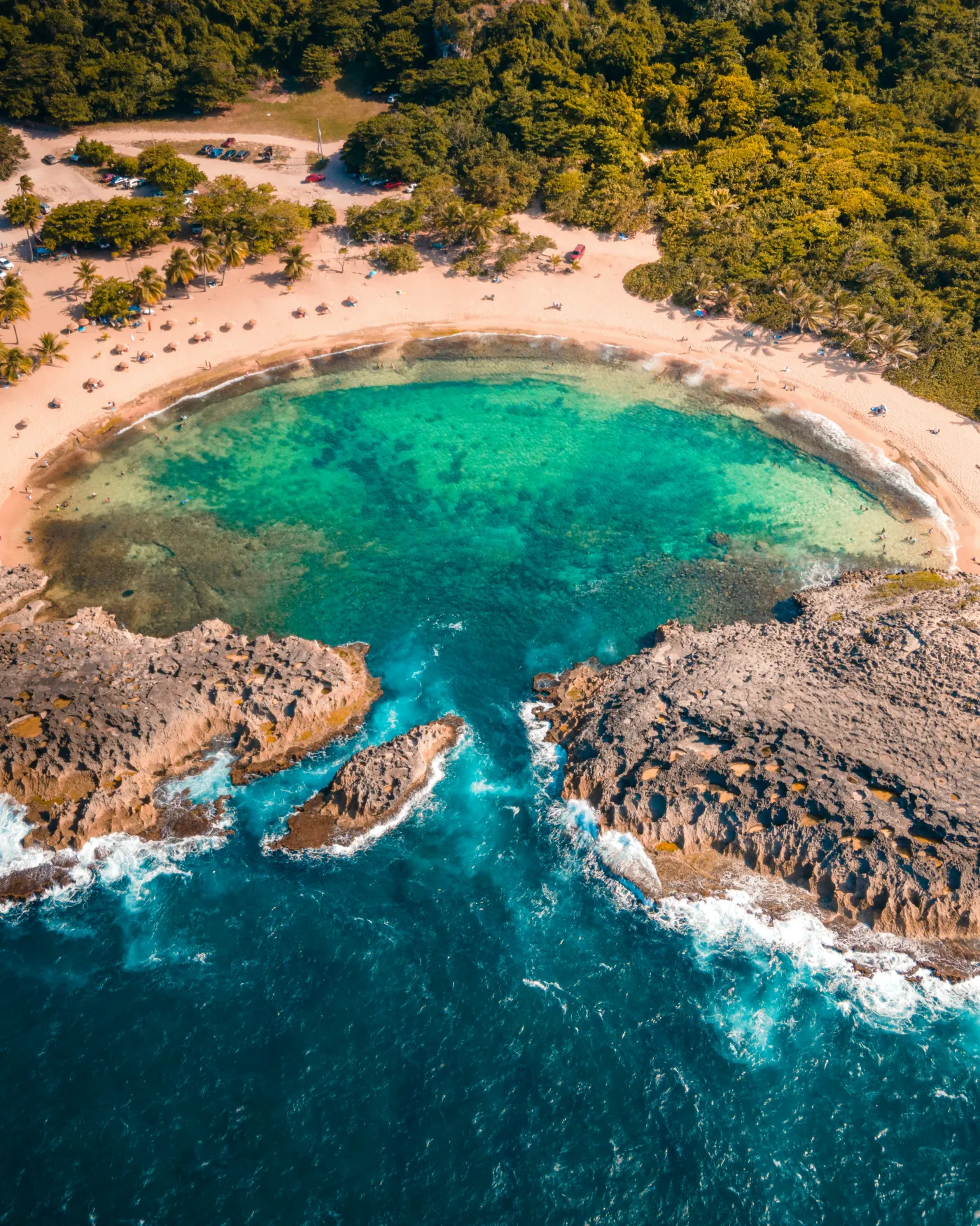 A secluded turquoise cove ringed by rock and green headland in Puerto Rico.