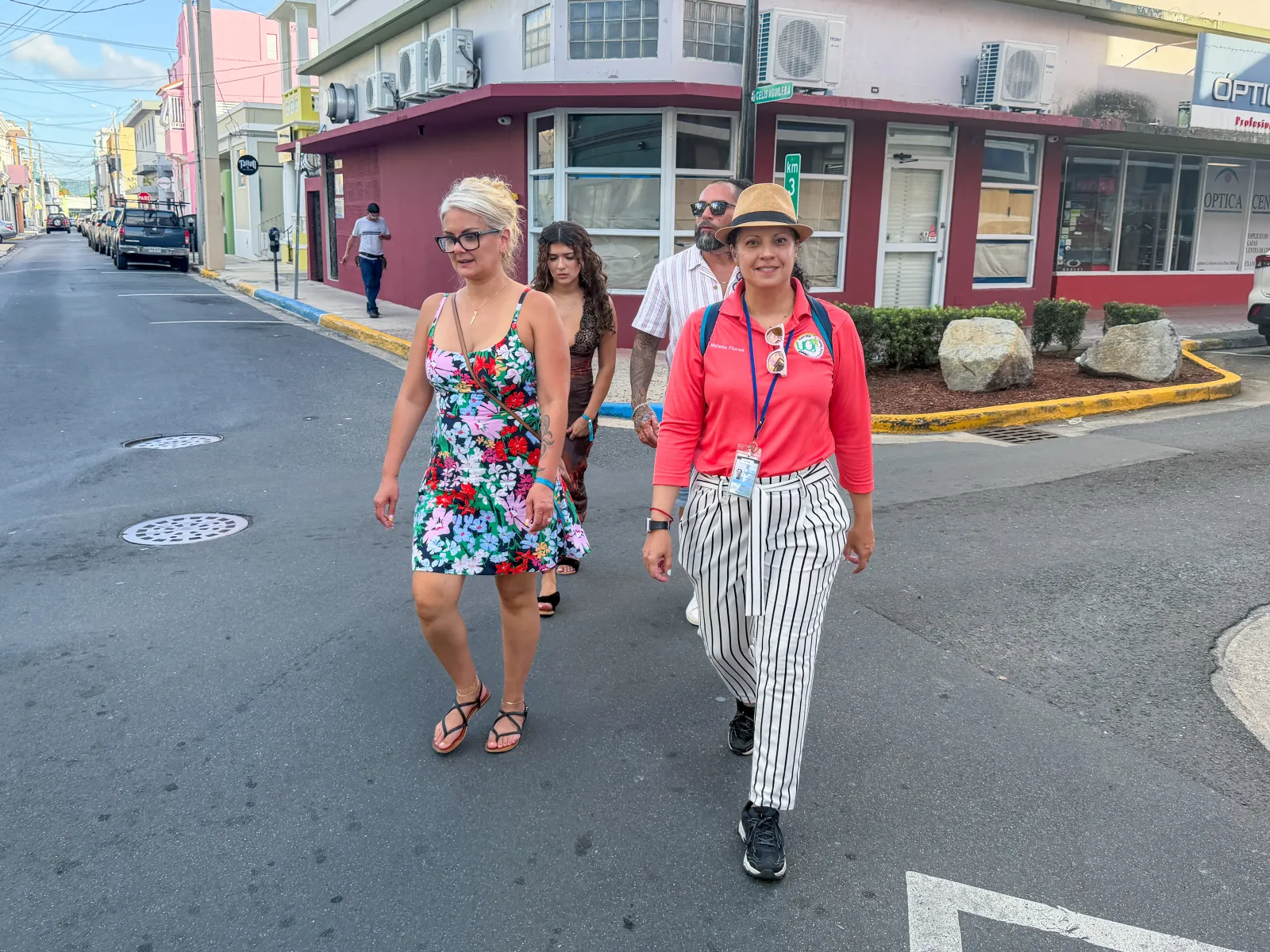 A guide walking travelers through a colorful street in Caguas.